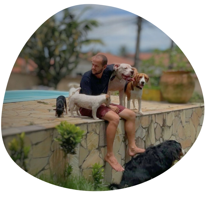 um homem sentado com cães ao seu redor